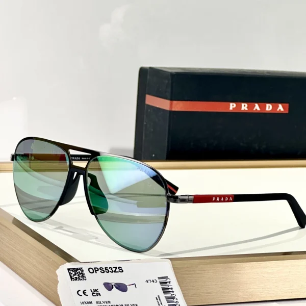 Sleek Prada Linea Rossa sunglasses laid flat next to branded accessories, emphasizing lightweight and aerodynamic shape