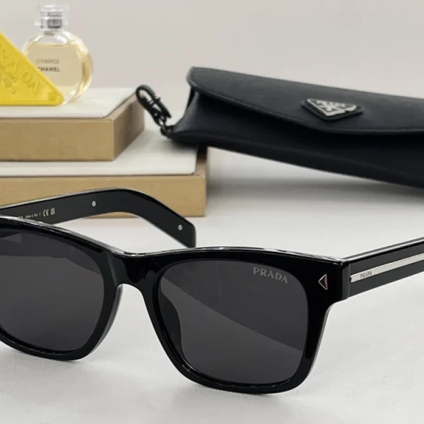 Classic Prada sunglasses with dark lenses and bold temple lines, accentuated by the signature metal Prada plaque
