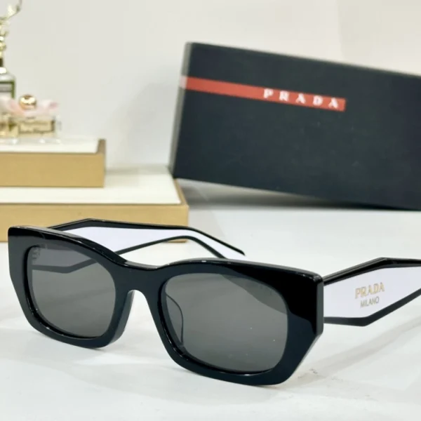 Prada sunglasses with bold Prada logo on wide temples, black acetate frame with gradient lenses
