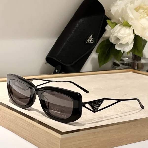 Prada sunglasses with signature triangle logo on temples, featuring sleek black acetate frame and dark lenses