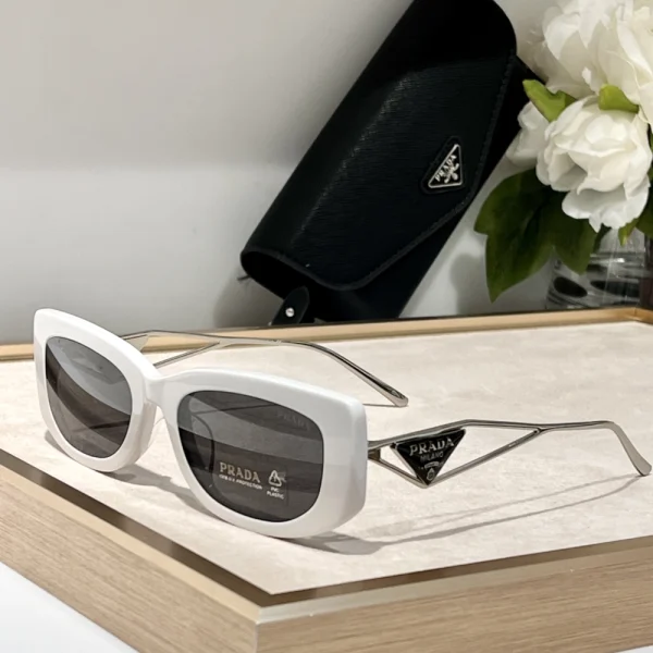 Front-facing Prada sunglasses with triangle metal logo visible on the temple, modern yet classic
