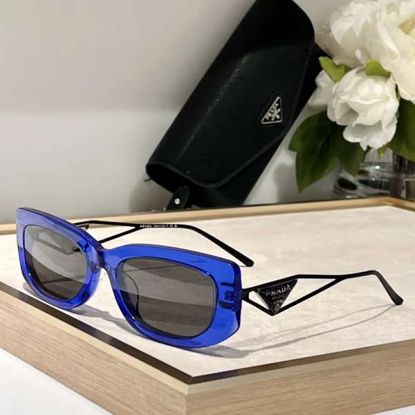 Prada triangle logo sunglasses styled with a luxury handbag and accessories for a high-fashion look