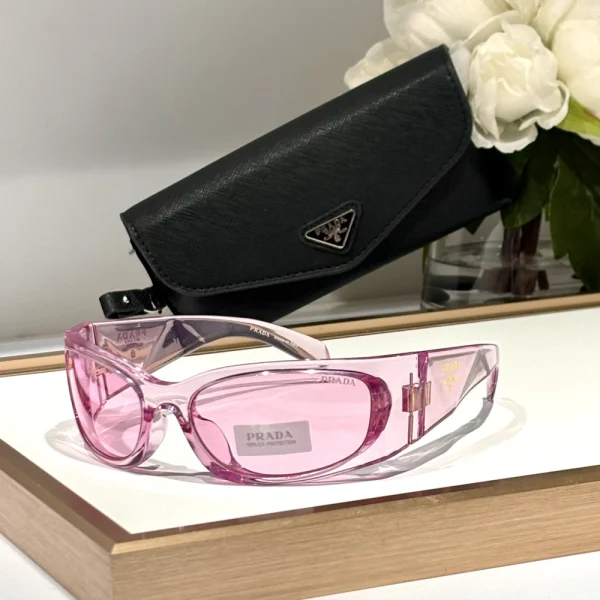 Close-up of Prada Symbole sunglasses showcasing thick black acetate frame and gold Prada triangle detail
