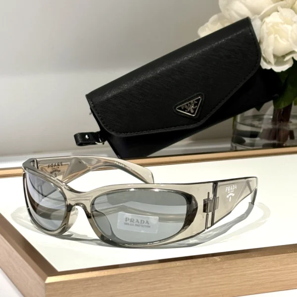 Elegant Prada Symbole sunglasses resting on cream velvet fabric, highlighting sculptural silhouette and high-shine finish