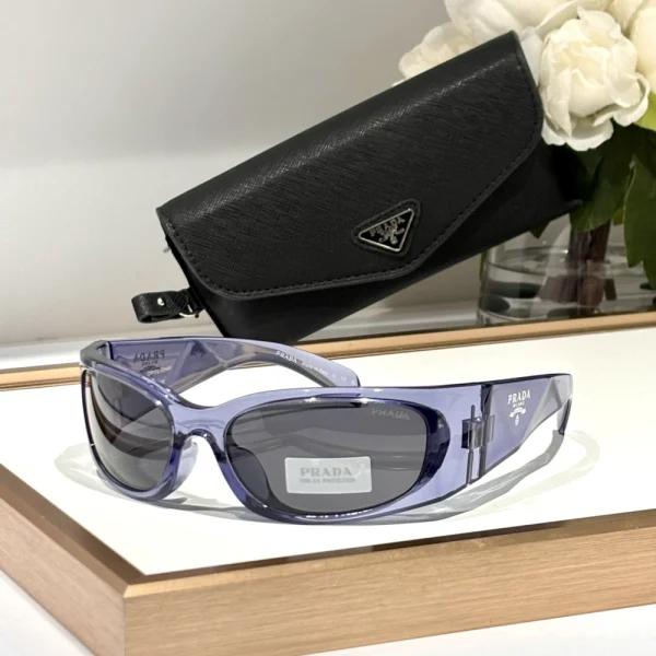 Prada Symbole sunglasses displayed flat with matching case and cloth, emphasizing architectural design