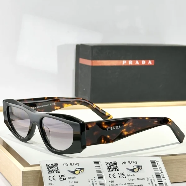Prada Symbole sunglasses with glossy tortoiseshell finish, placed on a marble surface under natural light