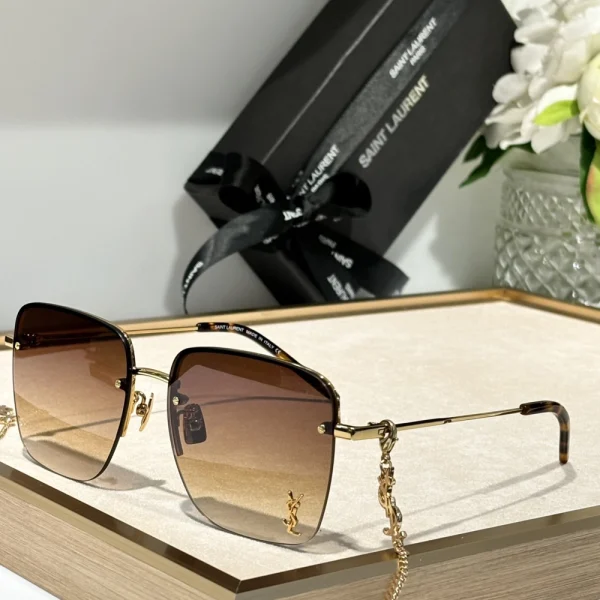 Saint Laurent SL 312 M sunglasses placed diagonally on marble surface, capturing glossy frame details
