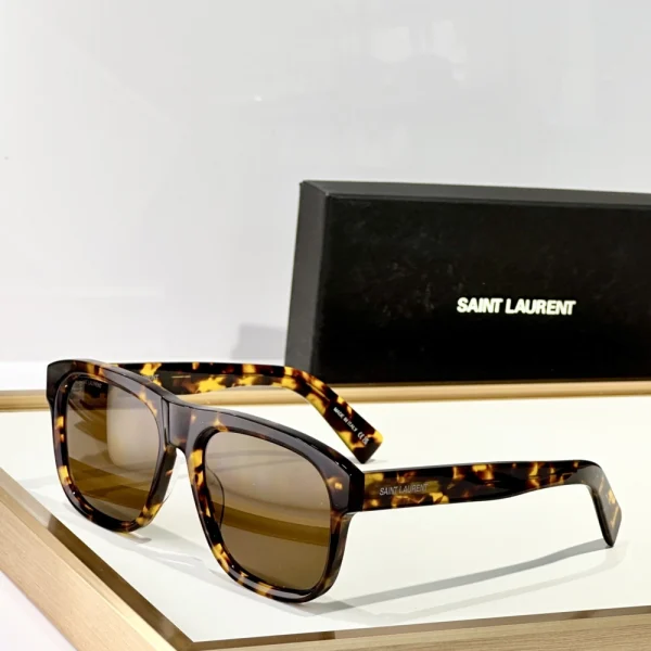 Saint Laurent SL 558 sunglasses placed diagonally on marble surface under soft daylight