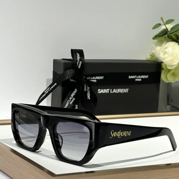 Elegant SL 740 sunglasses by Saint Laurent resting beside branded case and cleaning cloth