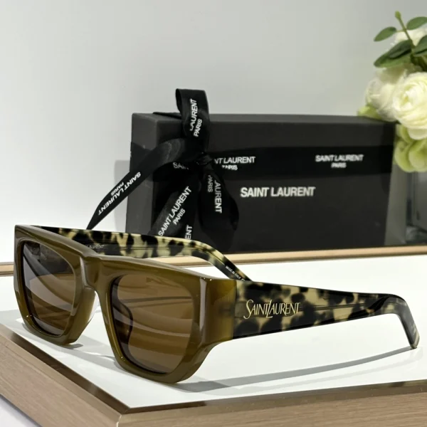 Saint Laurent SL 740 sunglasses placed diagonally on marble surface under soft daylight