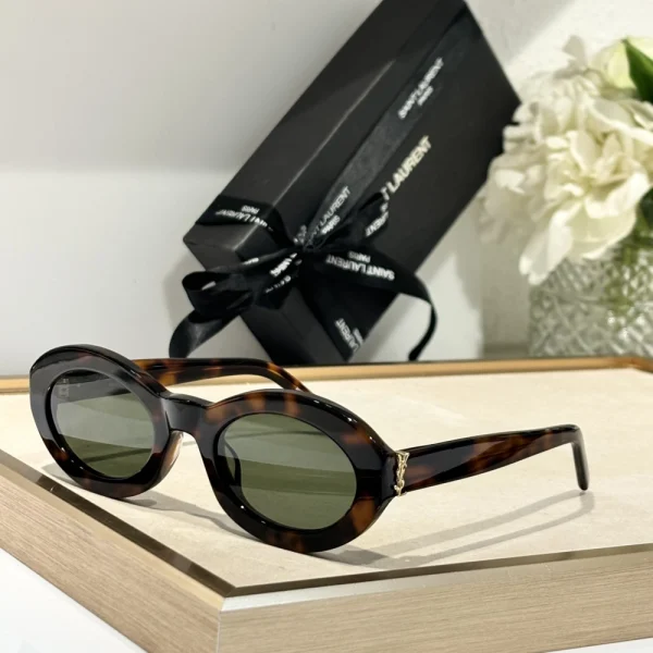 Elegant SL M136 sunglasses by Saint Laurent resting beside branded case and cleaning cloth