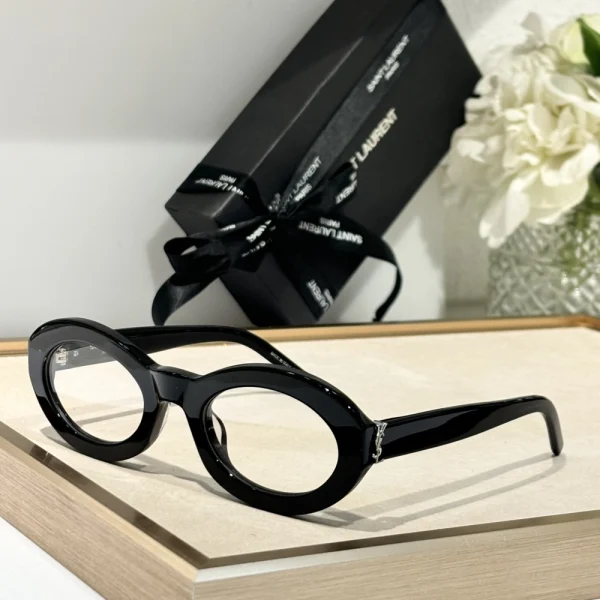 Saint Laurent SL M136 sunglasses placed diagonally on marble surface, emphasizing refined Parisian elegance