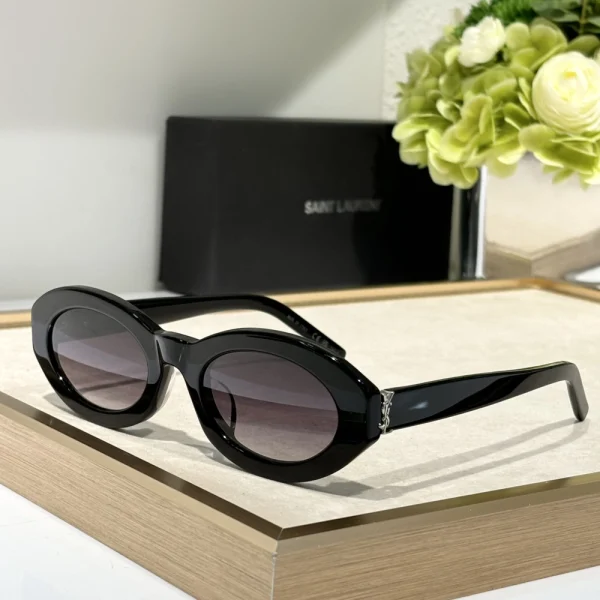 High-fashion Saint Laurent SL M136 sunglasses displayed with neutral-toned fashion accessories