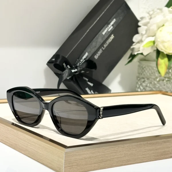 Black SL M148/F sunglasses by Saint Laurent displayed flat with signature eyewear case and booklet