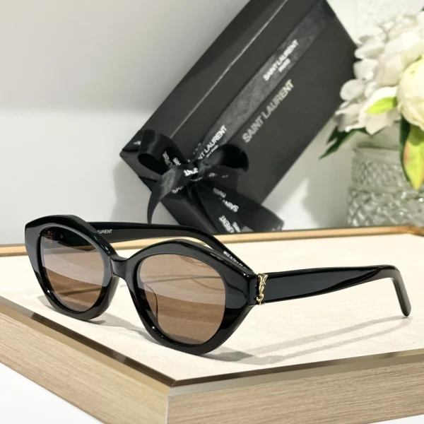 High-fashion Saint Laurent SL M148/F sunglasses captured under natural light, reflecting glossy frame texture