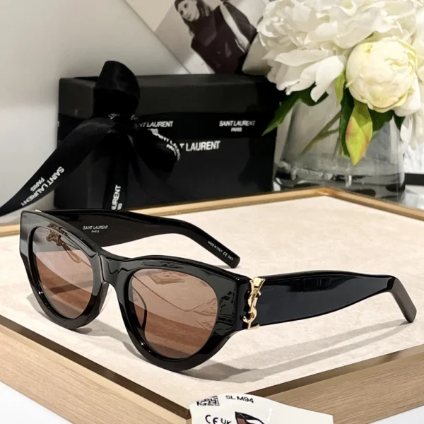 Saint Laurent SL M94 sunglasses with oversized black square frame and dark lenses, elegantly positioned on a glossy white surface