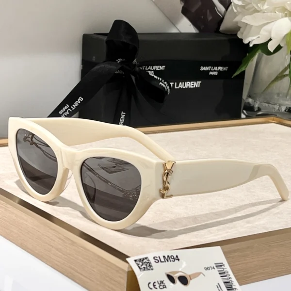 Flat lay of Saint Laurent SL M94 sunglasses beside original Saint Laurent eyewear box and booklet