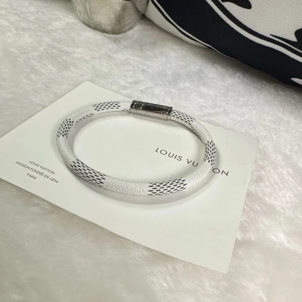 Close-up of Louis Vuitton Keep It Bracelet showing engraved LV buckle and monogram canvas detail