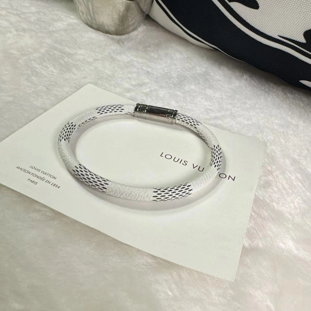 Close-up of Louis Vuitton Keep It Bracelet showing engraved LV buckle and monogram canvas detail