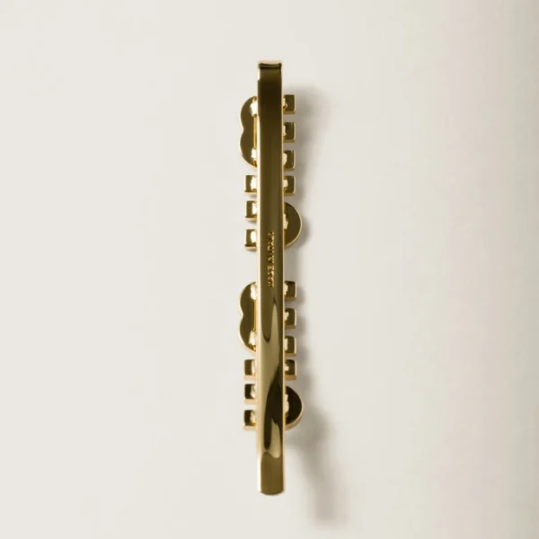 Side view of Miu Miu enameled metal hair clip highlighting clasp design