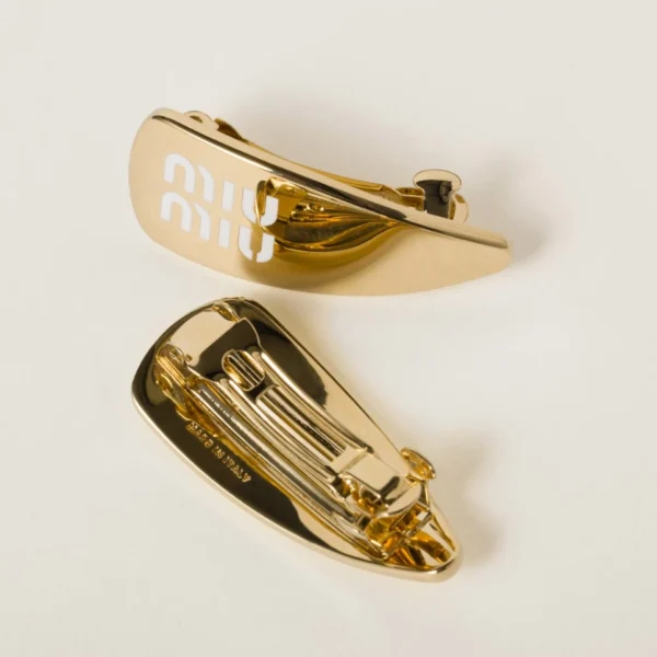 Miu Miu enameled metal hair clips displayed on neutral background emphasizing elegant craftsmanship