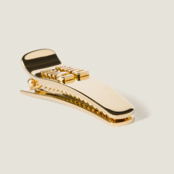 Miu Miu metal hair clip displayed on neutral background emphasizing elegant craftsmanship
