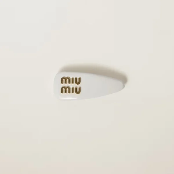 Close-up of Miu Miu patent leather hair clip highlighting smooth shiny surface and detailed edges
