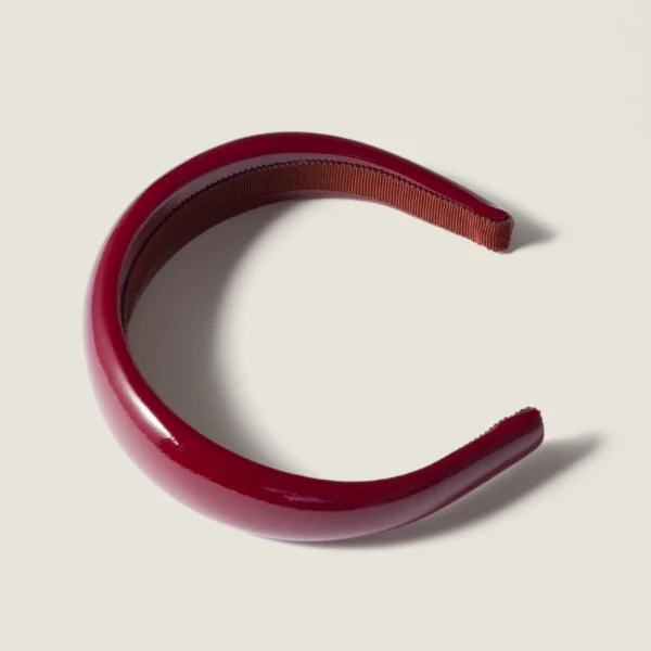 Close-up of Miu Miu patent leather headband highlighting smooth shine