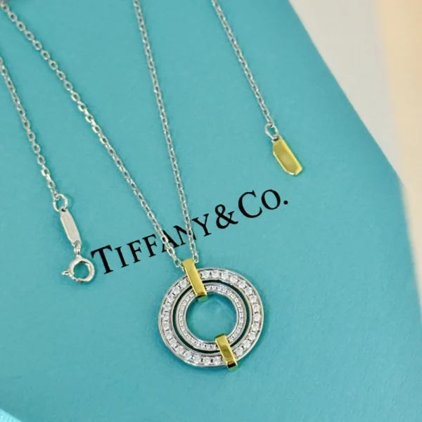 Close-up of Tiffany Edge Pendant in platinum and 18k yellow gold, featuring a circular silhouette and pavé diamond detail